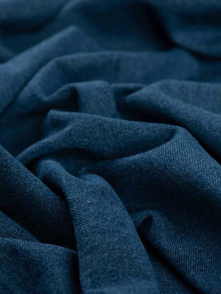 Twist of Workwear Blue 100% Cotton Denim, 330gsm, showing rich indigo-blue face with contrasting natural cotton weft and distinctive diagonal twill lines for classic denim texture.