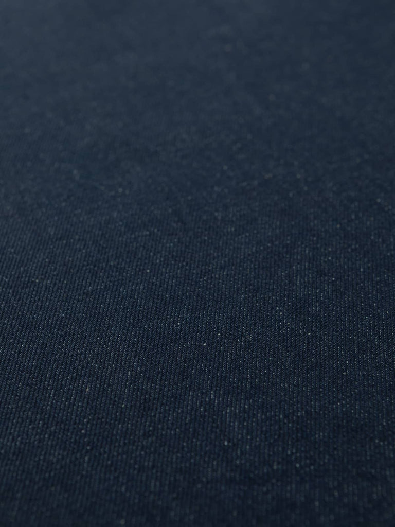 Angled flat view of Midnight Indigo Denim, 154cm wide, highlighting rich navy-indigo tone, visible diagonal twill weave, and subtle two-tone contrast between dark warp and pale weft.