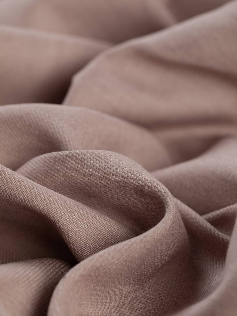 Showcasing the fabric's structure and flexibility, the angled twist highlights the texture and drape of Posie Rosie denim, giving a clear view of its durable yet soft cotton twill weave.