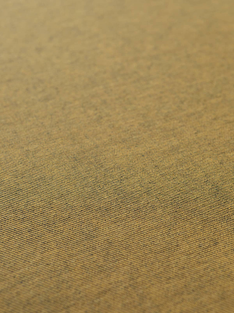 Angled flat view of Mustard Shot Denim, 166cm wide, revealing the inky navy face with subtle diagonal weave and warm mustard reverse for a striking contrast of tone and texture.