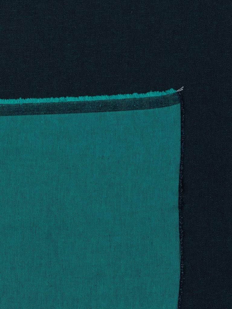 Overhead flat shot of Teal Shot Denim fabric, showcasing the refined contrast of navy warp and teal weft, creating a rich, dimensional finish that balances heritage denim character with modern vibrancy.