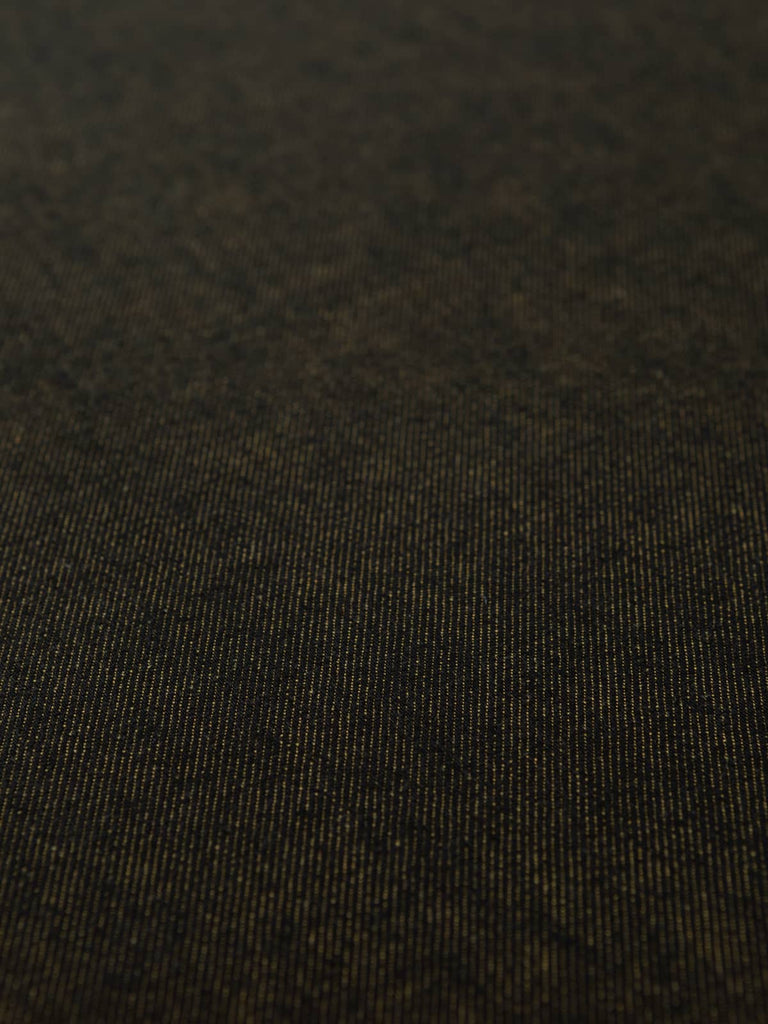 Overhead flat shot of Mustard Shot Denim fabric, capturing the rich interplay between dark navy warp and golden mustard weft, producing a sophisticated shot-effect surface with classic twill definition.
