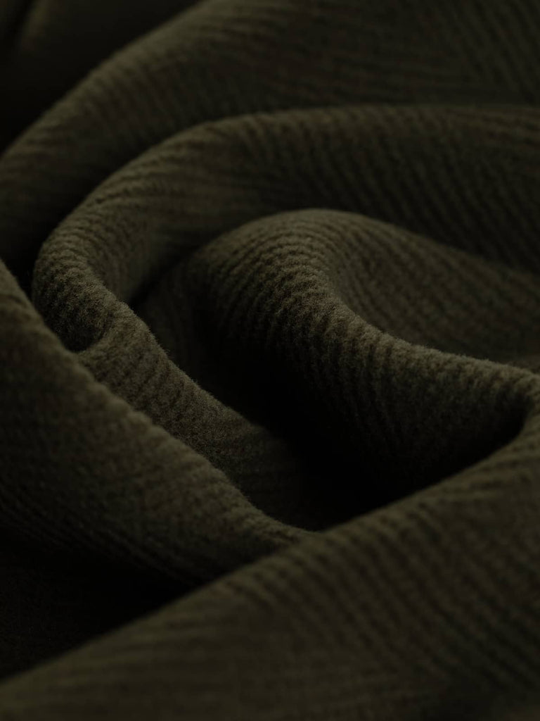 Image showcasing a luxurious wool fabric with a rich green-brown tone and prominent 6cm herringbone pattern. This hard-wearing fabric is well-suited for timeless overcoats, historical costumes, and modern home decor, providing a soft yet robust drape.