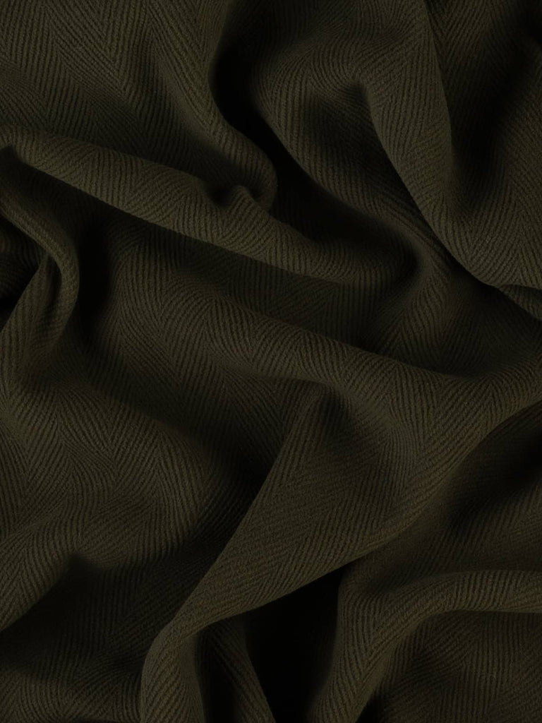 Close-up image highlighting premium wool fabric in a deep green-brown shade, featuring a distinctive 6cm herringbone design. This dense, double-faced fabric is perfect for chic winter coats, utility-style jackets, and soft furnishing projects like cushions and footstools.