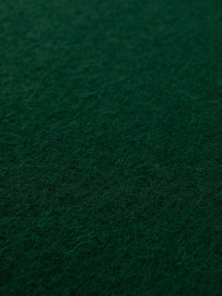 Angled flat view of Woodland Green Boiled Wool fabric, 140cm wide, capturing its earthy forest tone, smooth felted finish, and natural depth from the knitted boucle texture.