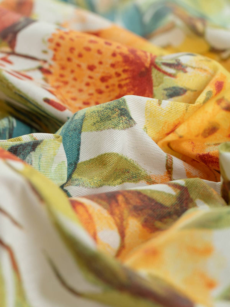 Fire Meadow features a pale cream background adorned with a vibrant watercolor pattern of palm fronds, seed heads, and exotic flowers in hues of tangerine, autumn red, rich brown, and teal. This water-resistant fabric is perfect for outdoor cushions, table covers, and picnic rugs.