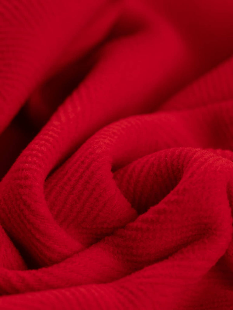 Detailed shot of Italian-made scarlet wool fabric, highlighting the prominent 6cm herringbone pattern. With a soft yet durable finish, this fabric is ideal for winter coats, upholstery, and historical costumes.