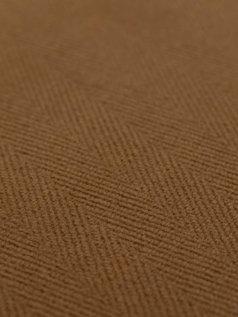 Close-up of tan wool fabric with 6cm jumbo chevrons. This heavy 100% wool fabric, reminiscent of antique tan leather, is ideal for crafting elegant overcoats, jackets, and upholstery projects, boasting a soft yet sturdy texture.