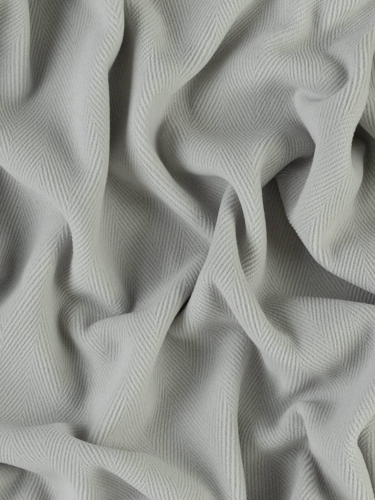 Image of a light grey wool fabric with a bold 6cm chevron design. This dense, heavyweight fabric is ideal for creating stylish coats, timeless duffle coats, or modern interior furnishings.