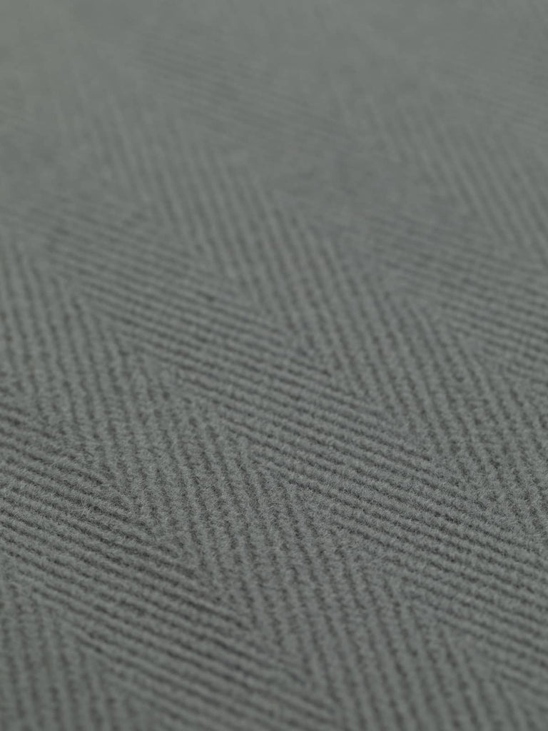 A detailed image of luxurious wool fabric in a flawless mid-grey hue, showcasing a 6cm herringbone pattern. This heavyweight fabric is perfect for sophisticated overcoats, stylish jackets, or modern upholstery projects, offering both elegance and durability.