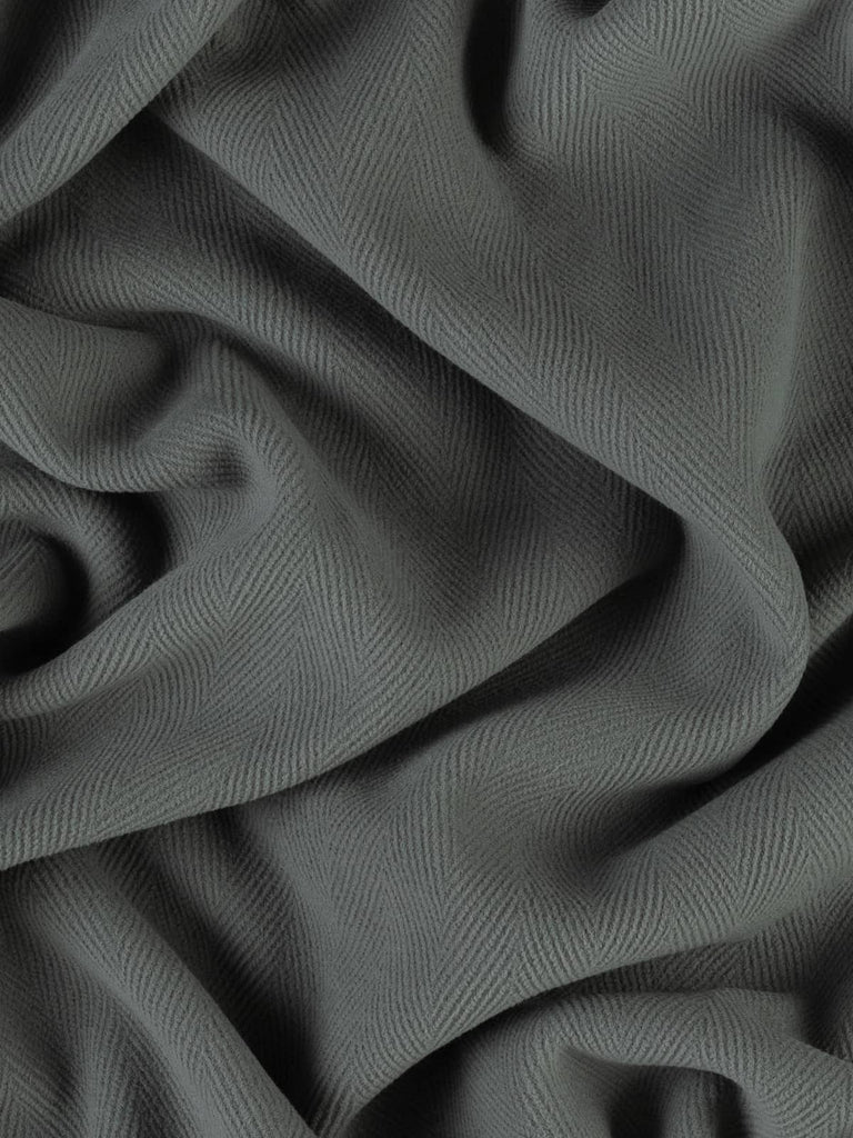 Close-up shot of premium wool fabric in a refined mid-grey tone, featuring a prominent 6cm chevron design. This dense, double-faced fabric is ideal for creating timeless winter garments and upscale home decor pieces like cushions or seat pads.