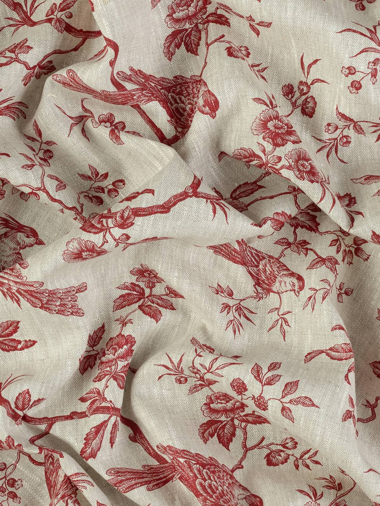 Top-down view of twisted linen fabric, highlighting the slubby weave and deep red botanical Rococo motifs on a beige melange base. Draped to emphasize its medium weight and elegant flow.