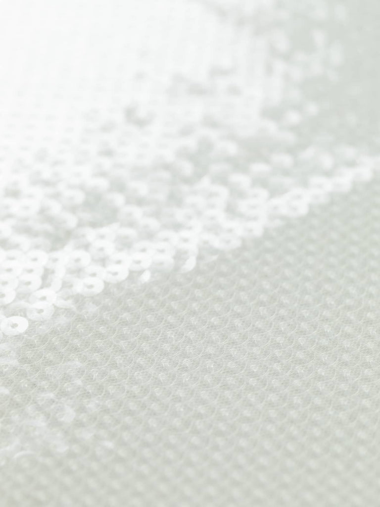 Flat-angled shot of Ethereal Pearl sequin fabric, showcasing rows of clear sequins stitched onto a natural white mesh. The surface glows with a subtle pearlescent sheen, evoking an ethereal, timeless charm.